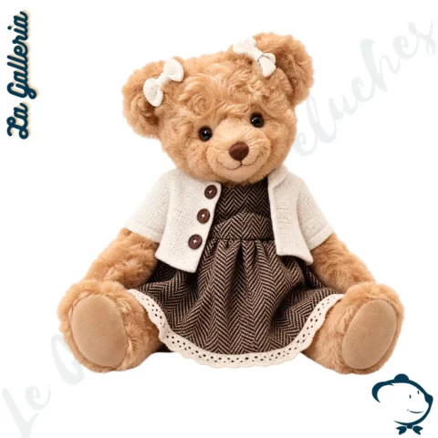 Margaret, oursonne en peluche La Galleria de 30 cm, vêtue d'une robe marron à chevrons, d'un cardigan beige et de petits nœuds crème.